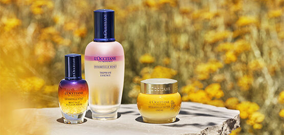 immortelle reset essence, reset serum and divine cream on ledge in front of immortelle field in corsica